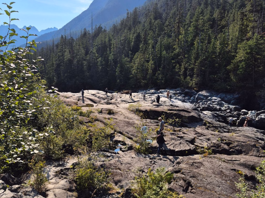 Vancouver Island Road Trip will include this Hwy 4 viewpoint near Cathedral Grove with people climbing over the rocks.